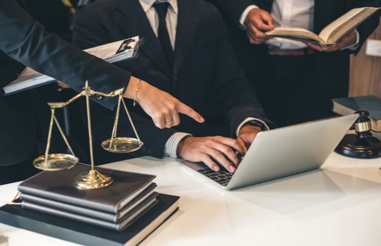 legal search advertising benchmarks - group of lawyers working on and pointing at computer