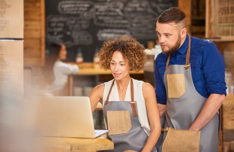 email marketing trends - two people in aprons look at a laptop