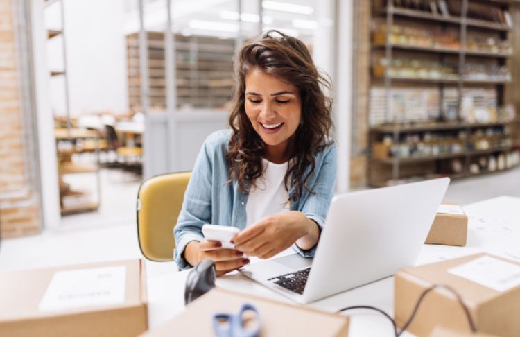 woman working on phone and computer at business