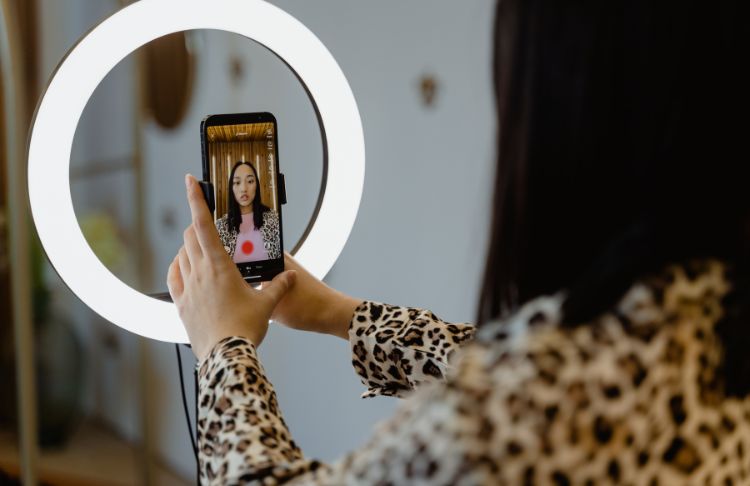 business woman filming tiktok video in front of ring light