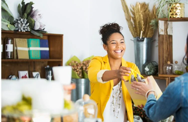 How to find customers - woman hands bag to a customer.