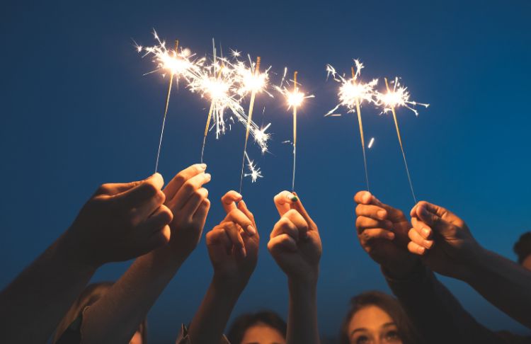 people holding sparklers above head