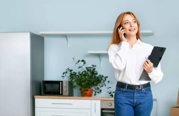 female business owner managing lead on phone holding clipboard