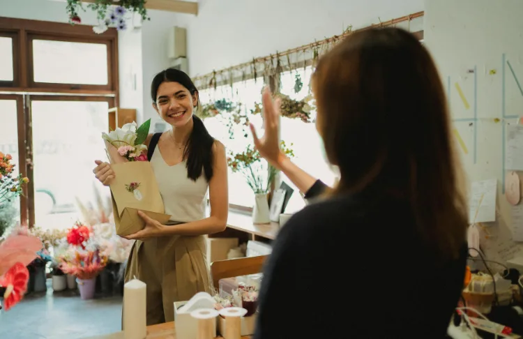 Loyalty program ideas - Customer holds bag while merchant waves.