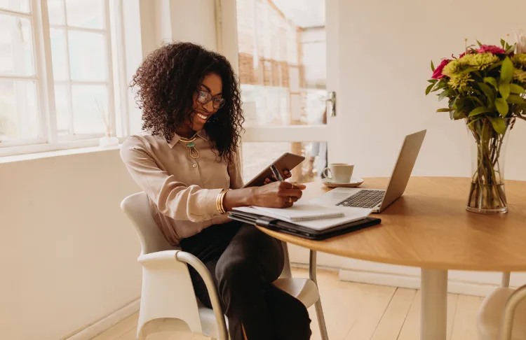 Email marketing trends - Woman looks at tablet and her laptop.