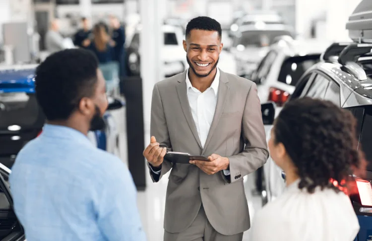 automotive marketing - car salesperson works with customers.
