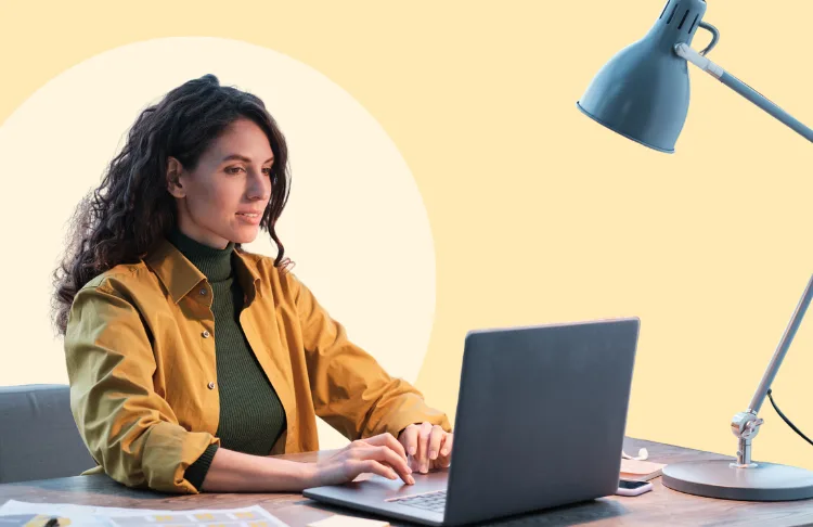 woman working on computer with yellow background